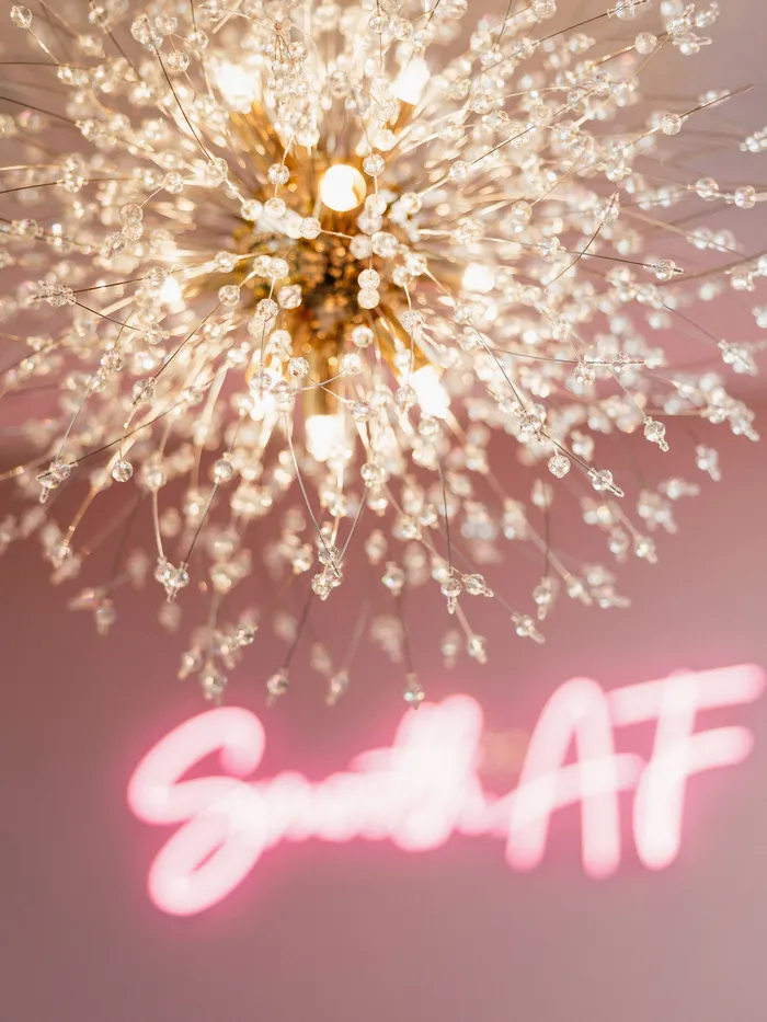 Crystal chandelier and the Smooth AF neon sign